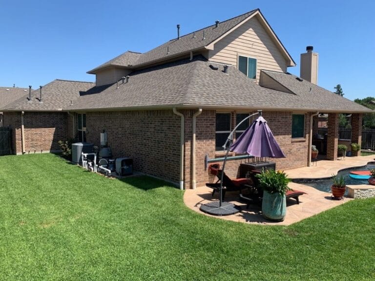 Brick house with patio and green lawn.