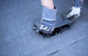 Person applying waterproof membrane on surface.